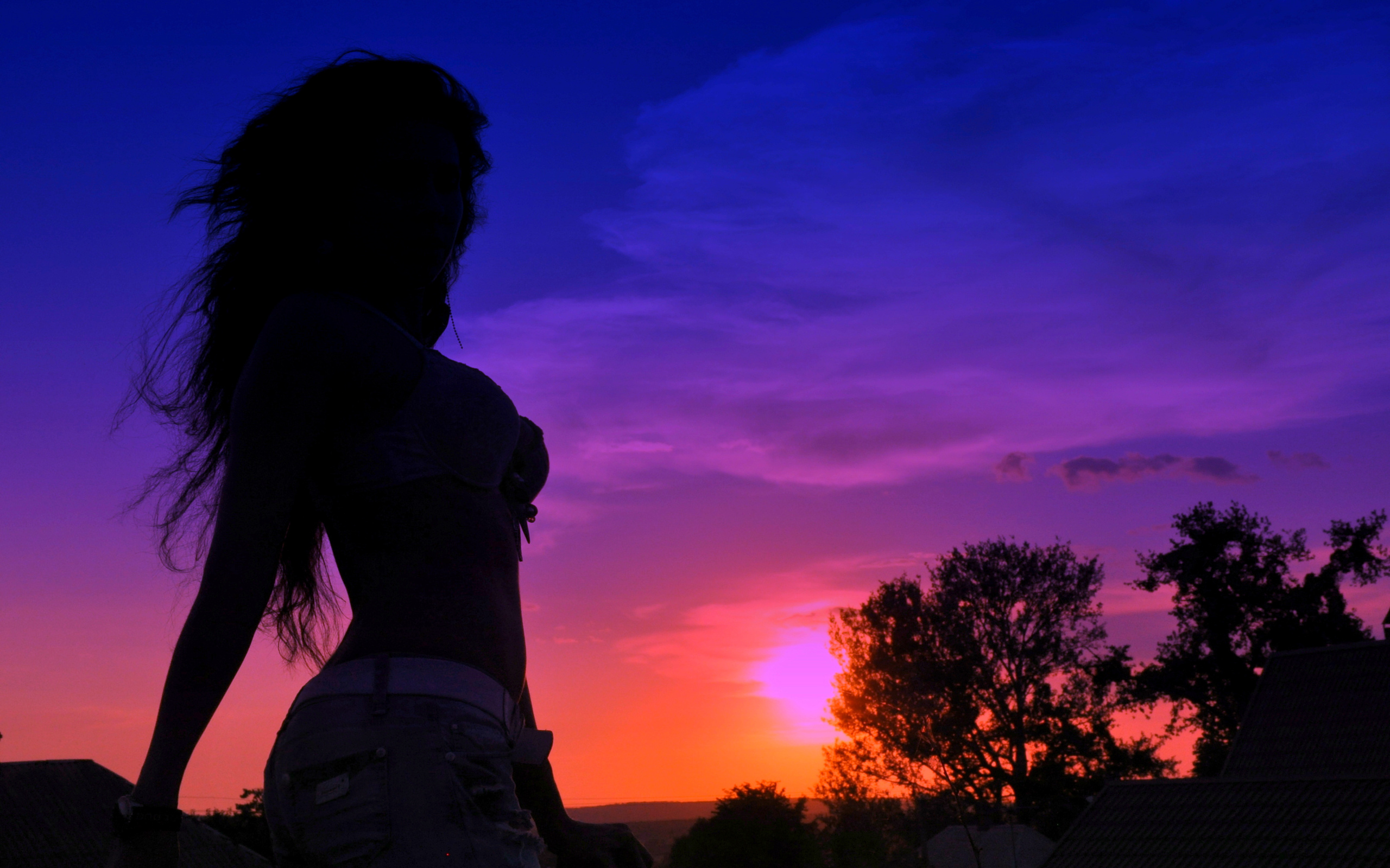 Девушка с красивой грудью на фоне заката