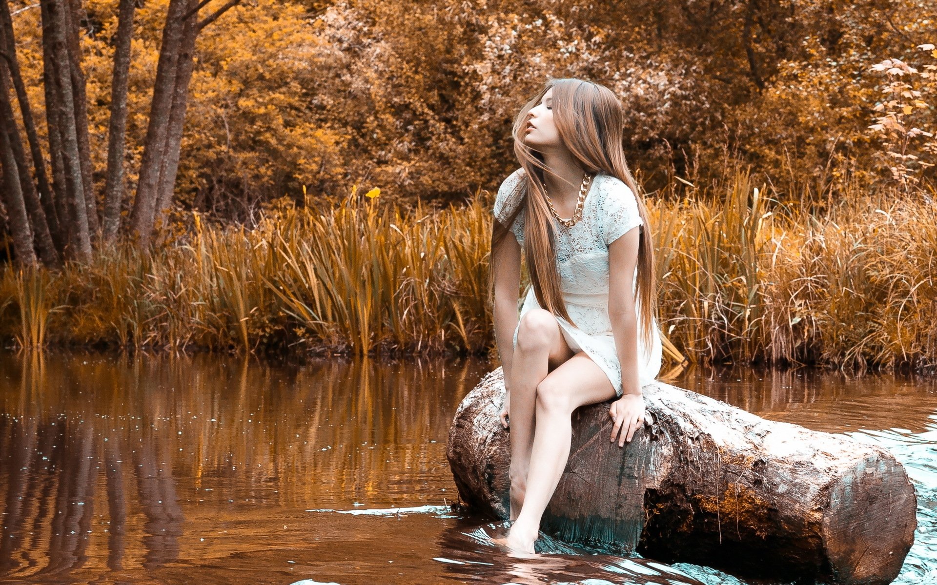 Голая девушка позирует на берегу реки