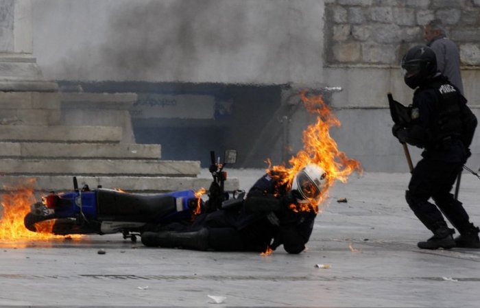 Горящий полицейский в Греции (2 фото)