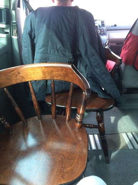 Водитель фургона с  деревянными стульями вместо сидений
