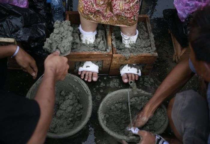 Жители Индонезии зацементировали ноги в знак протеста