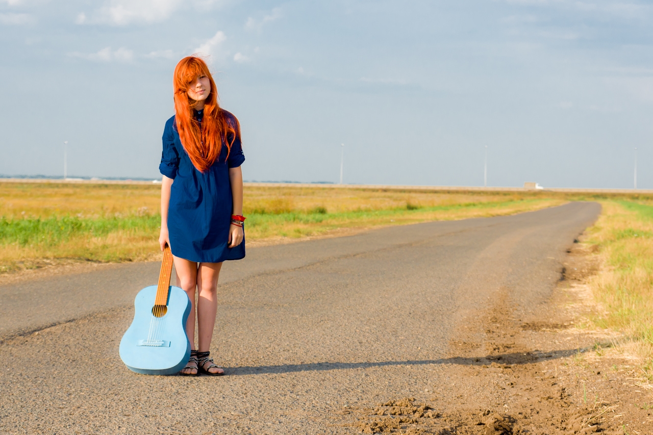 Песни в дорогу 2024. Рыжая девушка с чемоданом. Рыжая девушка с гитарой. Рыжая девушка дорога. Девушка с гитарой на дороге.