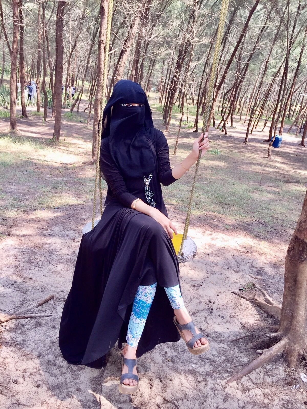 Девушка в хиджабе на качелях